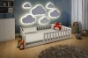 Beleuchtete Wolken-Wanddeko über einem weißen Kinderbett in einem modern eingerichteten Zimmer.