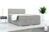 Modern grijs boxspringbed met gestoffeerd hoofdbord in een stijlvolle slaapkamer.
