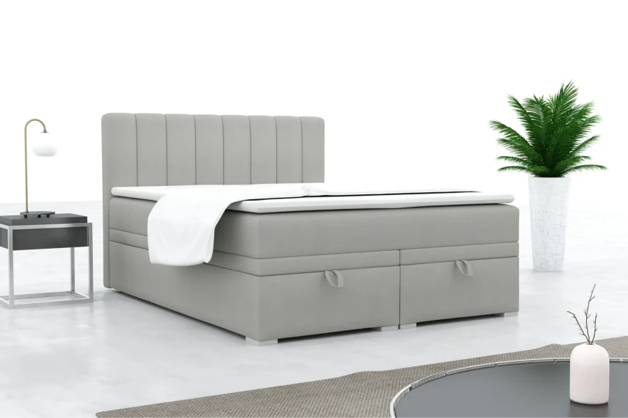 Modern grijs boxspringbed met gestoffeerd hoofdbord in een stijlvolle slaapkamer.