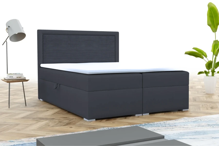 Modern donkergrijs boxspringbed met geribbeld hoofdbord en topper in een lichte slaapkamer.