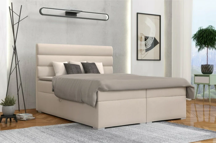 Modern beige boxspringbed in een stijlvol ingerichte slaapkamer.