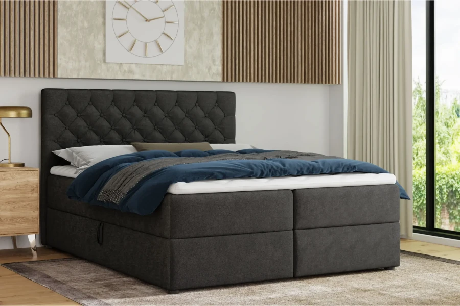 Modern donkergrijs boxspringbed met gecapitonneerd hoofdbord in een stijlvolle slaapkamerambiance.
