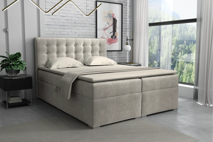 Modern beige boxspringbed met gestoffeerd hoofdbord in een lichte slaapkamer ambiance.