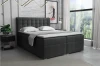 Modern grijs boxspringbed met gestoffeerd hoofdbord in de slaapkamer.