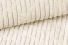 Detailed view of the beige cord upholstery fabric for the TAMI box spring bed.