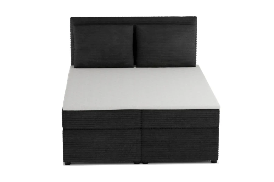 Vooraanzicht van een zwart boxspringbed met corduroy bekleding en twee kussens.