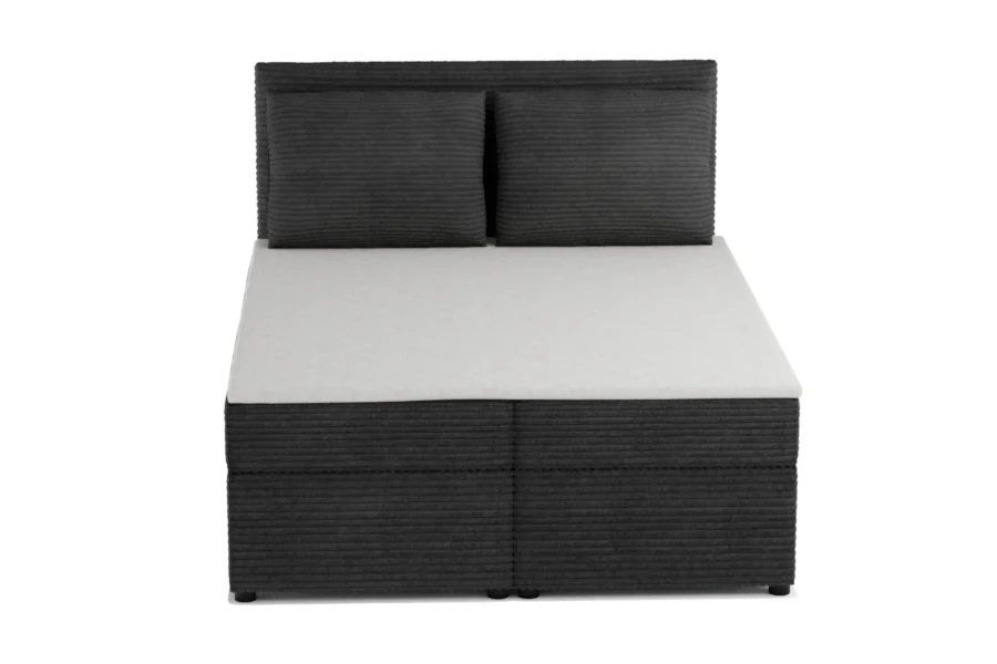 Antracietkleurig boxspringbed met ribstof bekleding en twee kussens voor een witte achtergrond.