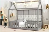 Graues Hausbett mit gepolstertem Kopfteil im Zickzack-Design, Lichterkette und Haus-Regalen.