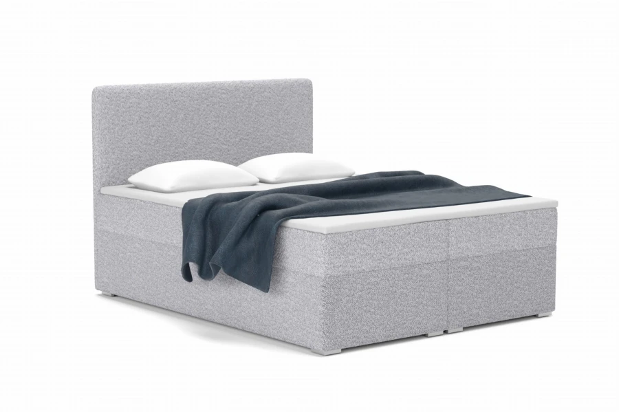 Hellgraues Boxspringbett mit Bouclé-Struktur und blauer Wohndecke.