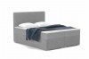 Graues Boxspringbett mit weichem Bouclé-Bezug und blauer Decke.