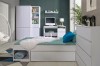 Modernes weißes Jugendzimmer mit Bett, Schreibtisch und Kleiderschrank vor dunkelgrüner Wand.