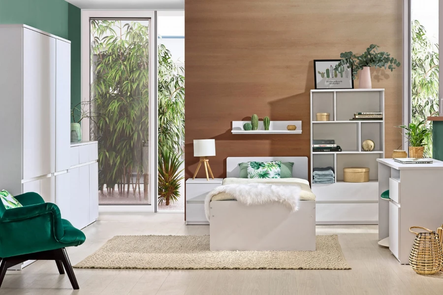 Helles Kinderzimmer in Weiß mit Bett, Regal und grünem Sessel für eine frische Optik.