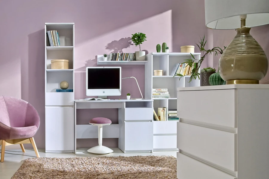 Weißer Schreibtisch mit Regalen, lila Wand und bequemem rosa Polstersessel im Arbeitszimmer.