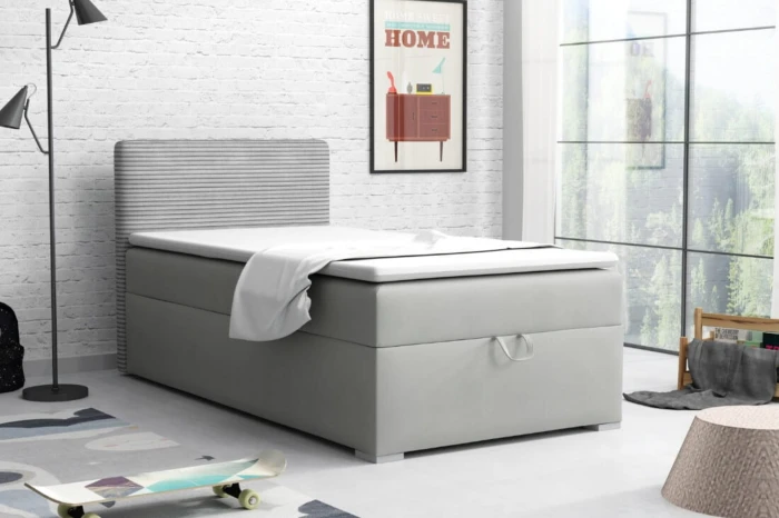 Moderne tienerkamer met grijs boxspringbed, skateboard en decoratieve bakstenen muur.