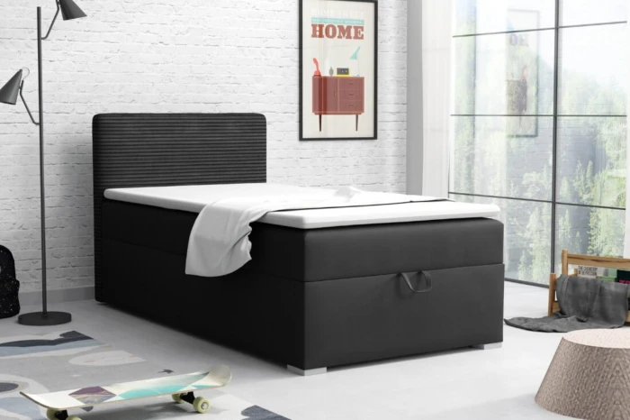 Modern black box spring bed in a bright bedroom with industrial brick wall.
