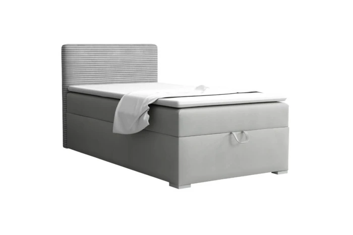 Modern boxspringbed in lichtgrijs met geribbeld hoofdbord tegen een witte achtergrond.