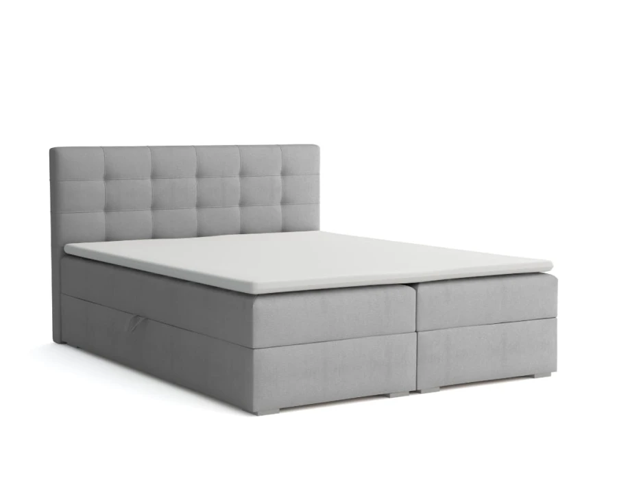 Hellgraues Boxspringbett mit quadratisch gestepptem Kopfteil.