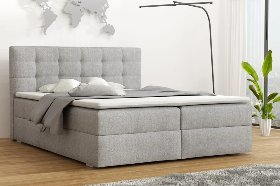 Modernes Boxspringbett in Grau im wohnlichen Schlafzimmer-Ambiente.