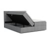 Graues Boxspringbett mit geöffnetem Bettkasten für viel Stauraum unter der Matratze.