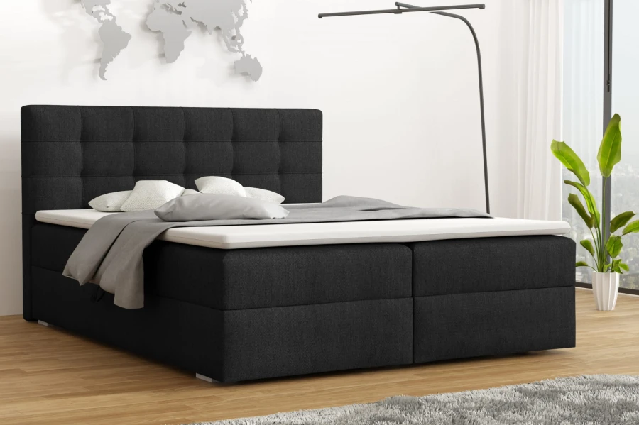 Modernes Boxspringbett in Anthrazit mit gepolstertem Kopfteil in einem stilvoll eingerichteten Schlafzimmer.