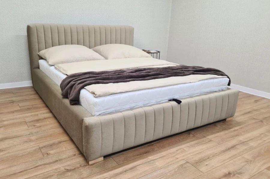 Beiges Polsterbett mit Matratze und gemütlicher Bettwäsche in einem modernen Schlafzimmer.