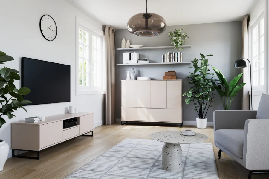 Modernes Wohnzimmer mit beige TV-Lowboard, Sideboard, rundem Couchtisch und grünen Zimmerpflanzen.