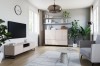 Modern eingerichtetes Wohnzimmer mit beigem Highboard, TV-Möbeln und Zimmerpflanzen.