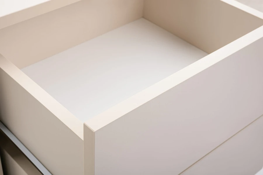 Nahaufnahme einer geöffneten beige Schublade einer modernen Nachtkonsole.