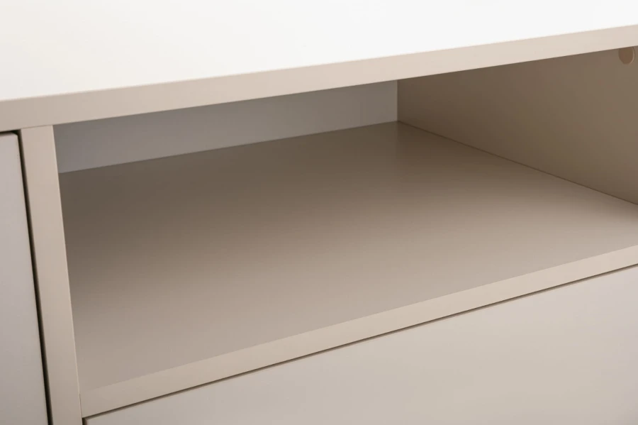 Nahaufnahme des offenen Ablagefachs eines beigen TV-Lowboards für Multimedia-Geräte.