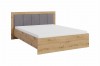 Stilvolles Doppelbett in Eichenoptik mit grau gepolstertem Kopfteil und weißer Matratze.
