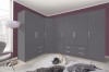 Grauer Eckkleiderschrank in einem modern eingerichteten Schlafzimmer.