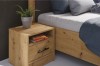 Detailansicht Nachtschrank Eiche Artisan mit Schublade neben hölzernem Bettrahmen.