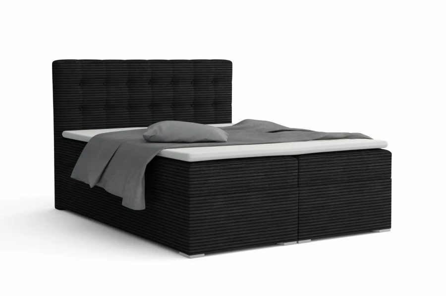 Modernes Boxspringbett in schwarzem Cord mit weißem Topper und grauer Decke.
