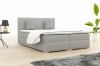 Hellgraues Boxspringbett im modernen Schlafzimmer mit Pflanze.
