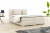 Beiges Boxspringbett mit Kopfteil und Kissen in heller Optik.