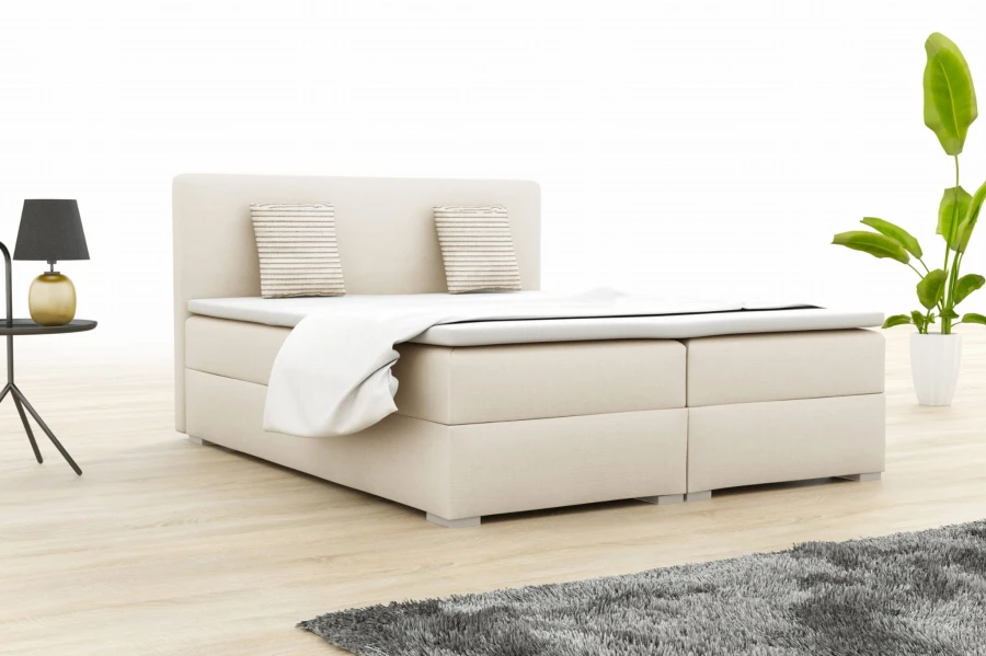 Beiges Boxspringbett mit Kopfteil und Kissen in heller Optik.