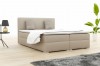 Beiges Boxspringbett im Schlafzimmer mit moderner Einrichtung und Pflanze.