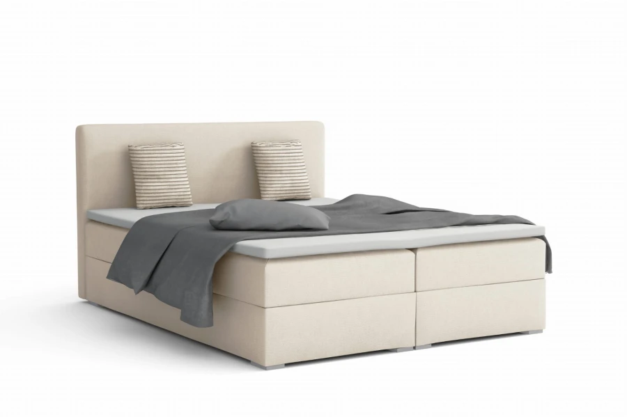 Crèmekleurig boxspringbed met grijze kussens en elegante look.