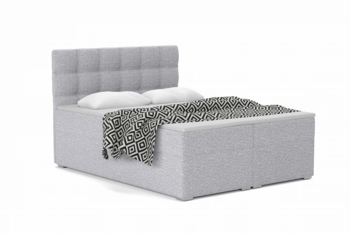 Modern grey box spring bed with quilted headboard and black and white bedspread.
