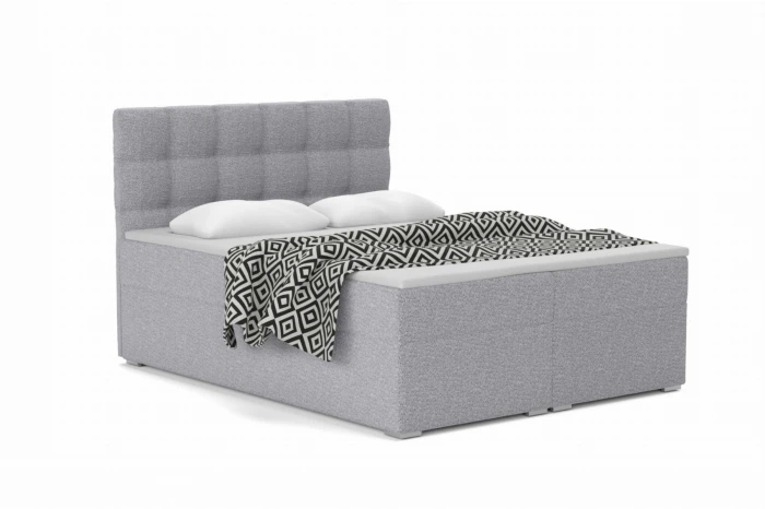 Modern grey box spring bed with high headboard and black and white bedding.