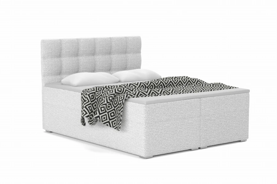 Wit boxspringbed met gecapitonneerd hoofdbord en zwart-wit gedessineerd beddengoed.