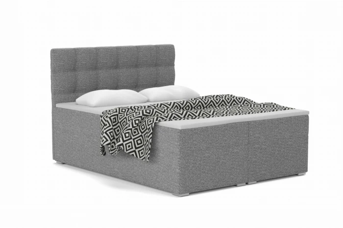 Grijs gestoffeerd bed met structuurbekleding, kussens en grafisch gedessineerde deken.