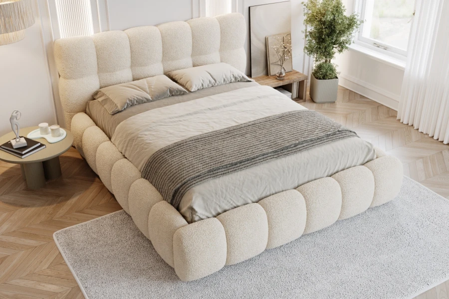 Elegantes Doppelbett aus Bouclé mit gepolstertem Kopfteil in heller, moderner Atmosphäre.
