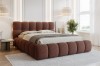 Modernes terracotta-farbenes Polsterbett aus Bouclé in einem hellen Schlafzimmer.