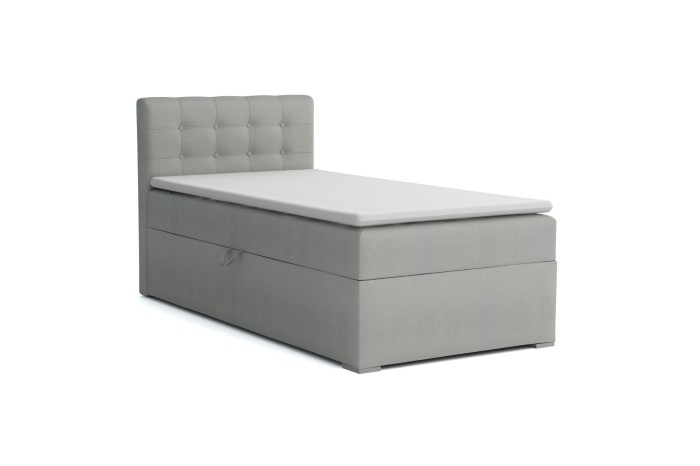 Lichtgrijs boxspringbed met bedbak en gecapitonneerd hoofdbord op een witte achtergrond.