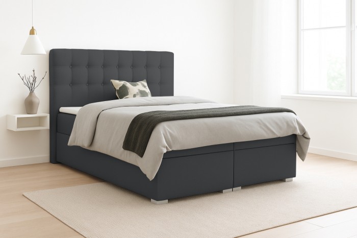 Dunkelgraues Boxspringbett Claudia mit gestepptem Kopfteil in einem hellen, modernen Schlafzimmer.