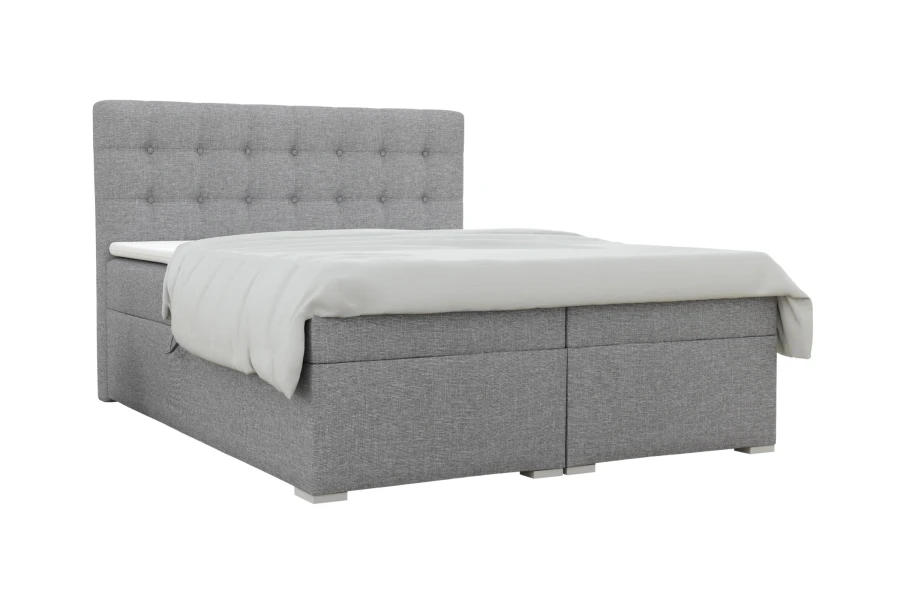 Hellgraues Boxspringbett mit Knopfheftung am Kopfteil vor weißem Hintergrund.
