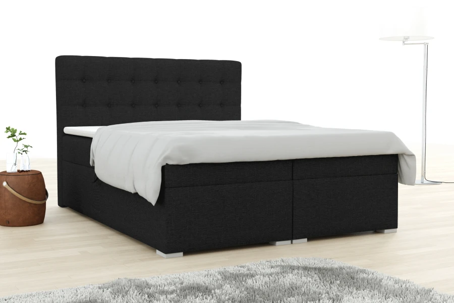 Modernes schwarzes Boxspringbett mit gepolstertem Kopfteil und weißer Bettwäsche im Schlafzimmer.