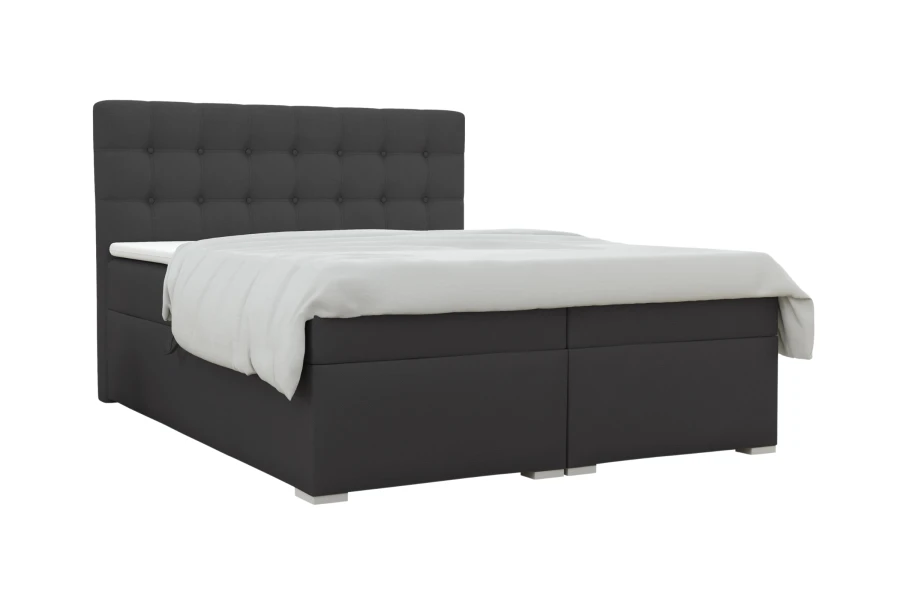 Dunkelgraues Boxspringbett mit gestepptem Kopfteil auf weißem Hintergrund