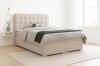 Beiges Boxspringbett in modernem Schlafzimmer mit hellem Teppich und Nachttisch